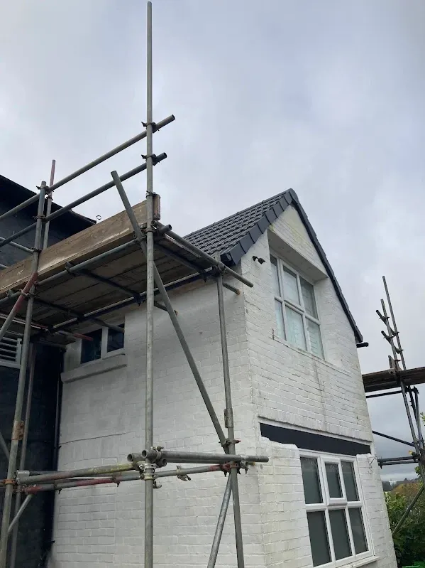 House under scaffolding during a full new roof installation in Kent