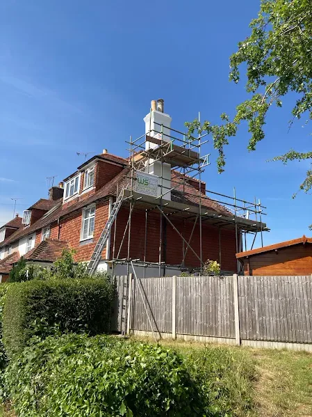 Scaffolding around a chimney on a red brick house during chimney repairs in Kent