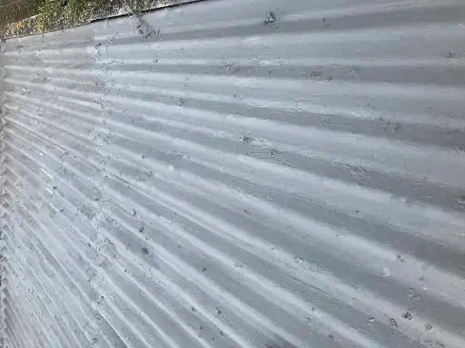 Corrugated roof with fresh grey coating after roof spraying