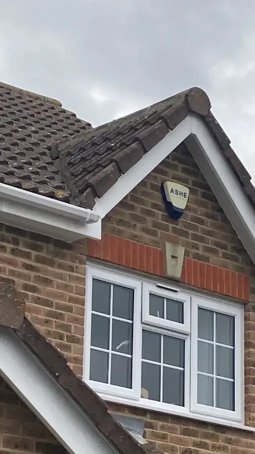 White UPVC fascias and guttering below a tiled gable roof