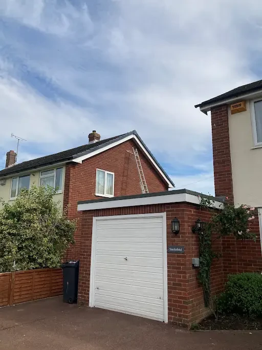 Ladder against the gable of a red brick semi-detached house in Kent