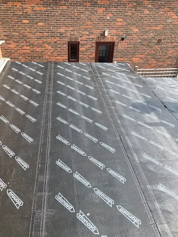 Flat roof membrane being installed on a brick extension in Kent