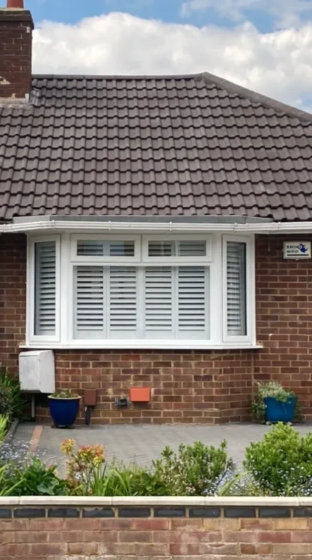 Brick bungalow with a clean tiled roof and white bay window after roof cleaning